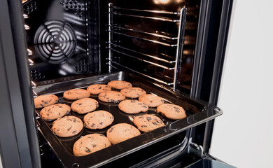 Chocolate cookies on the baking. Baking of freshly baked chocolate chips cookies. 