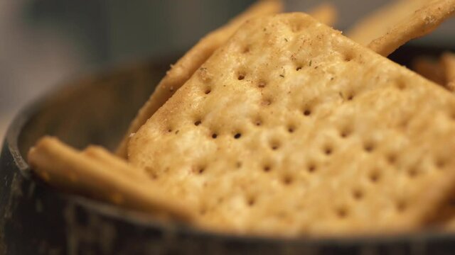 Rotating texture of Movin cracker with salt in a plate close-up, bokeh. High quality 4k footage