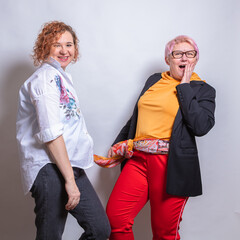 Personal stylist. Helps a client, a middle-aged woman, to choose a style.
Clothes, fashion, style and people concept - woman choosing clothes in home wardrobe