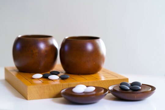 black and white stones on wooden board with copy space (goban, baduk, weiqi board game)