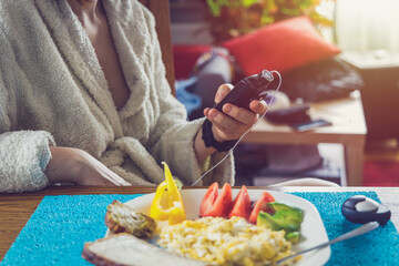 Modern diabetes treatment, woman checking glucose level and dosing insulin with insulin pump before...