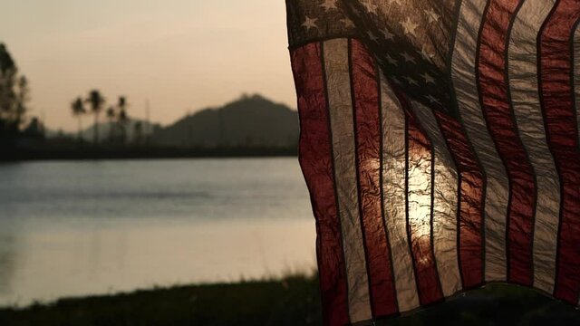 Happy Memorial Day. American flag waving on sunset or sunrise background with soft focus, Slow Motion. Concept of Memorial Day or 4th of July, Independence Day, Veterans Day, American Election