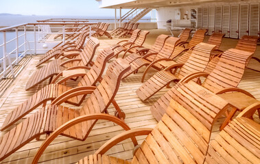 Vue de chaises longues en bois sur le pont arrière d'un navire de croisière.