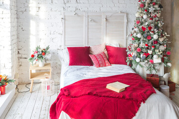 A spacious white light bedroom in a loft style with a decorated Christmas tree and a garland.