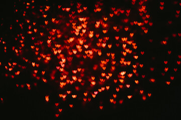 Fototapeta na wymiar Red heart shaped blurry bokeh background.