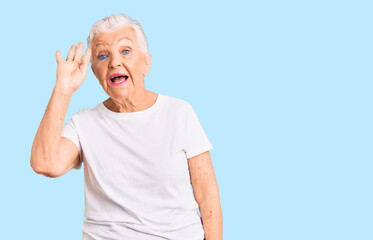 Senior beautiful woman with blue eyes and grey hair wearing casual white tshirt waiving saying hello happy and smiling, friendly welcome gesture