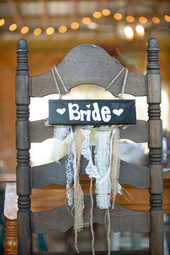 Brown Bride and groom chairs at wedding recetion sweetheart tablewith bokeh backgrounds