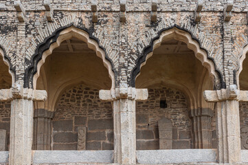 Hampi, Karnataka, India - November 5, 2013: Zanana Enclosure. detail of gray stone facade with peacock bows where archeological artifacts are displayed.