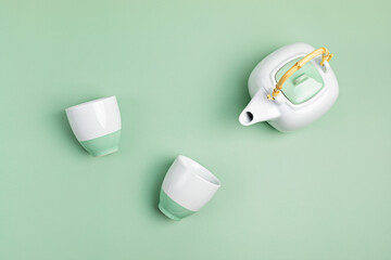 White ceramic tea pot with cups on pastel background. Eco friendly organic brand concept. Branding mockup. Flat lay