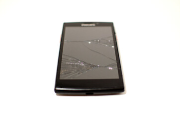 black cell phone with broken screen. electronic equipment repair concept. crack on smarton glass.
