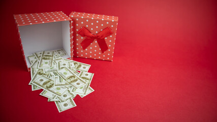 Money in a box on a red background.