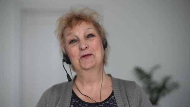 Cheerful older 60s woman looking talking to camera conference calling at home. Smiling senior mature adult lady grandmother speak to webcam do video chat communicate online, web cam view