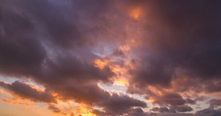 Natural color dramatic dawn or dusk sky with painterly yellow, pink and blue clouds with horizon, taken with wide angle 35 mm lens for sky replacement