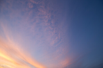 Natural color dramatic dawn or dusk sky with painterly yellow, pink and blue clouds with horizon,...