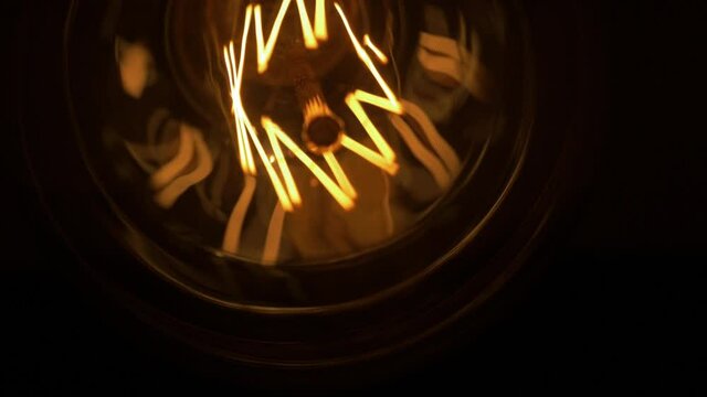 Close-up of a classic incandescent set of two lamp. Glass bulb, inert gas and tungsten filament. Soft natural light. Lamp velvet effect. Is flaring up brighter and brighter. Super macro.