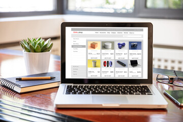 Online shop website design template on a computer monitor, office desk background.