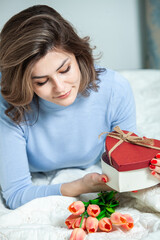 Beautiful girl open red heart gift box. Valentine's day. Happy Birthday.  Girl receives a gift at home.