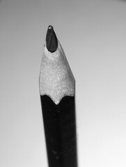 Monochrome photo of the point of a sharpened wooden pencil.