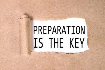 PREPARATION IS THE KEY, text on white paper over torn kraft paper background