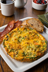 Omelette. Classic American brunch or breakfast menu item served at traditional American restaurant. Farm fresh eggs, cooked in butter with fresh vegetables pork, bacon, cheese and served with salad 
