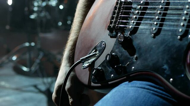 Guitarrest plugs in an electric guitar on stage.
