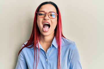 Young caucasian woman wearing casual clothes and glasses sticking tongue out happy with funny expression. emotion concept. © Krakenimages.com