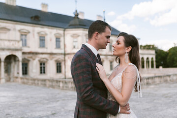 Bride and groom embracing and looking at each other in the background of palace