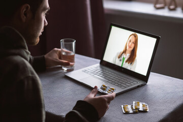 A man receives online advice from his doctor about taking pills. The concept of the Remote Medical Pandemic.