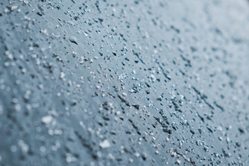 Melting snow and water drops on glass surface. Abstract blue tone background. Selective focus.