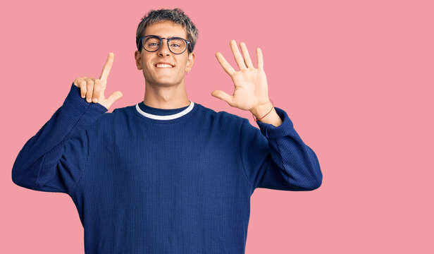 Young handsome man wearing casual clothes and glasses showing and pointing up with fingers number seven while smiling confident and happy.