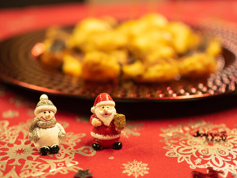 Puff pastry sausage rolls on christmas plate with Santa Claus and snowman.
