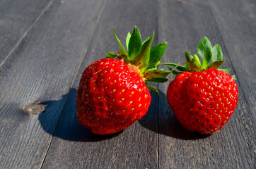 Strawberries on a wooden table in the summer outdoors