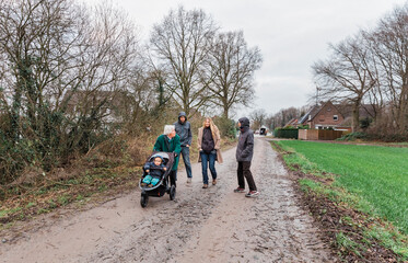Fototapeta premium Multi-generational family walking on footpath between fields