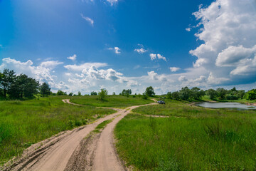 Fototapeta na wymiar road in the field and clouds in the summer