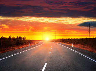 Evening landscape. Car road at sunset with dramatic sky