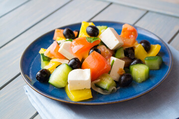 Greek salad with cucumber, tomato and pepper, lettuce, onion, feta cheese and olives