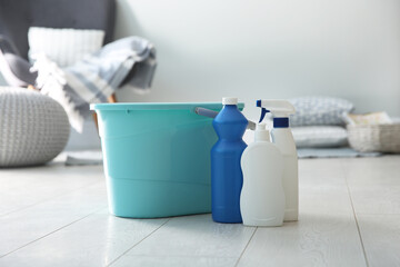 Bucket and different cleaning products on floor indoors