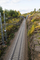 The railway passes through rocky passage on autumn day