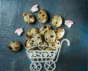 quail eggs and decorative rabbits in a white metal cart, easter concept, easter still life