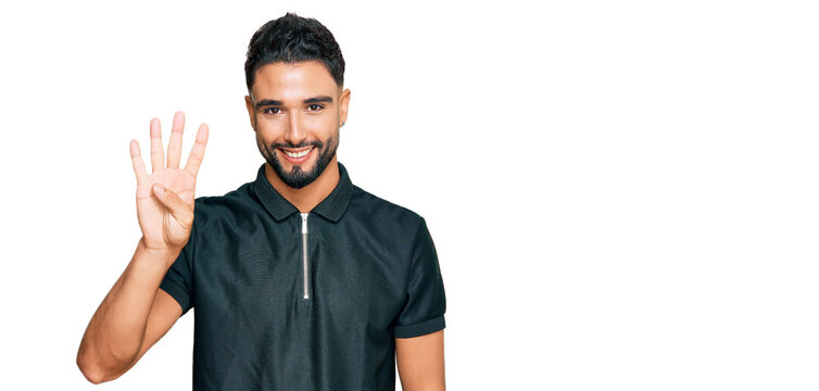 Young man with beard wearing sportswear showing and pointing up with fingers number four while smiling confident and happy.