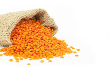 Uncooked raw red lentil in burlap sack isolated on white background, (Lens culinaris)