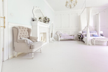 bright, clean stylish interior bedroom and living room with a large panoramic window. beautiful rich antique furniture. four-poster bed, a mirror and a sofa.