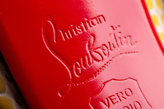 Moscow, Russia - January 2021: Red leather soles of women shoes with Christian Louboutin logo. Pressed logo Christian Louboutin. Leather sole in red leather.