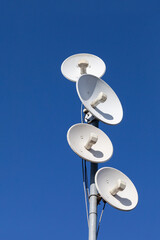 Several telecommunications antennas of a cellular network and wireless internet against a blue sky....