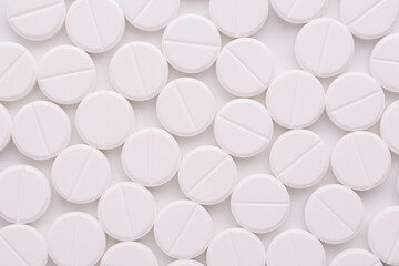 Round white pills background. Lots of round tablets. Round pills top view.