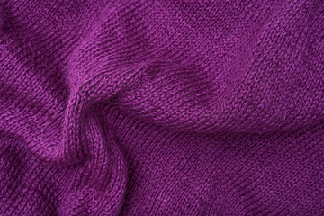 Fototapeta na wymiar Woolen crumpled purple fabric as background close-up, violet knitted clothes, crochet and knitting