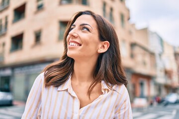 Young hispanic woman smiling happy walking at the city.