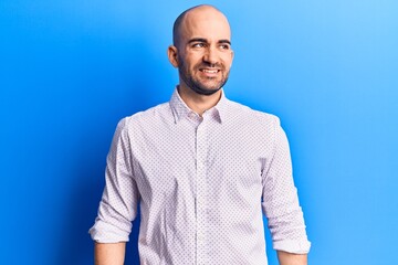 Young handsome bald man wearing elegant shirt looking to side, relax profile pose with natural face and confident smile.
