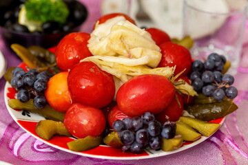 Fototapeta na wymiar Salted tomatoes, cucumbers, cabbage on a plate..