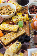 Granola Bars and mixed nuts. Honey bars with peanuts, chocolate, dried fruit, sesame and sunflower seeds